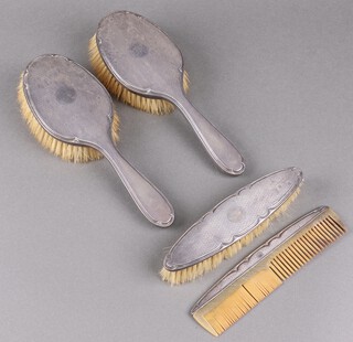 A 4 piece silver backed dressing table set comprising pair of hair brushes, clothes brush and comb, Birmingham 1929 