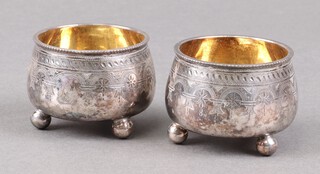 A pair of Victorian silver salts with parcel gilt interior, engraved decoration with armorial on bun feet, Sheffield 1873, by Joseph Rogers & Sons, 68g 