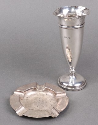 A circular silver ashtray, monogrammed, Birmingham 1939, 69g, together with a silver trumpet shaped specimen vase London 1910, 16cm, (misshapen and dented) 