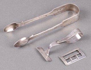 A pair of Georgian silver fiddle pattern sugar tongs London 1804, a child's silver pusher and a silver buckle, 89g