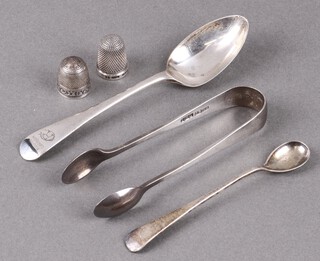 A silver Old English pattern teaspoon, ditto long handled salt spoon, pair of silver sugar tongs and a silver thimble, 60g 