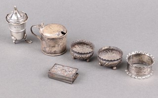 A pair of Victorian silver salts with embossed decoration Birmingham 1886, a silver pepper (foot a/f), silver mustard (no liner), silver match slip and a napkin ring, 115g 