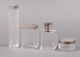 An Art Deco cut glass dressing table jar with silver engine turned lid Birmingham 1939, a rectangular glass scent bottle with glass stopper and silver lid (slight chip to stopper) Birmingham 1939, a glass pin jar Birmingham 1940 and 1 other Birmingham 1940, all marked Bill 