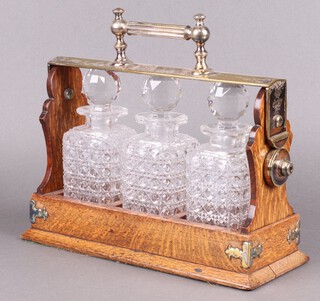 An oak and silver plated Betjemann 3 bottle tantalus, marked H Rodrigues  
