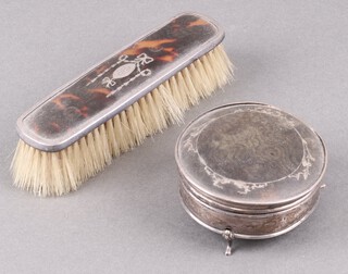 A circular silver and tortoiseshell trinket box with hinged lid on panel feet, 8cm,  Birmingham 1926 and ditto clothes brush Birmingham 1924 