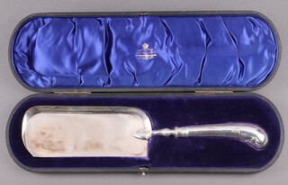 A cased silver crumb scoop with pistol grip handle and armorial decoration, Sheffield 1909 by Harrison Brothers, gross weight including handle, possibly weighted, 251g