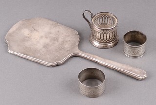 Two silver napkin rings and a Sterling glass holder, 69g, together with a silver backed hand mirror Sheffield 1936 