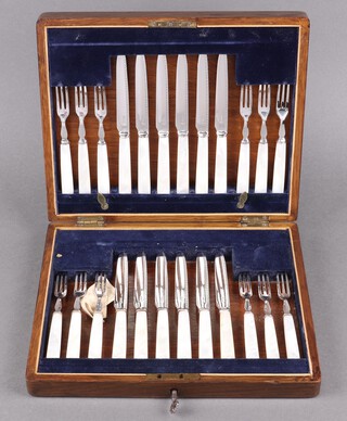 A cased set of 12 fruit knives and forks with silver blades and mother of pearl handles, contained in an oak canteen box 