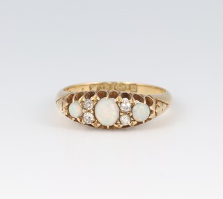 An 18ct 3 stone opal and 4 stone diamond set ring, size M, 3.5g 