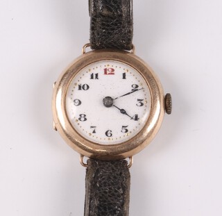 A lady's Swiss wristwatch with enamelled dial, Roman numerals, movement marked Swiss Made 15 jewels, contained in a 9ct gold case, with leather strap, 15g gross 