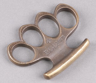 A World War One brass metal combat knuckle duster marked BC42 MkII with broad arrow, 12cm w