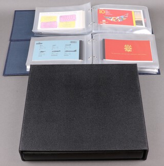 Two albums containing approximately 50 GB Elizabeth II presentation stamp sets together with an album containing mint GB stamps 