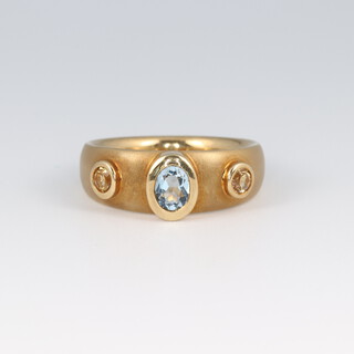 An 18ct brushed gold ring set an oval aquamarine and 2 citrine, size N,  8.8g 