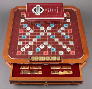 A Deluxe Scrabble set by Franklin Mint, comprising a wooden board on a revolving turn table, fitted drawers containing gold plated letter tiles, racks and scoring sheets  