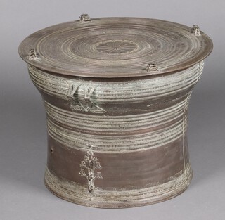 A bronze rain drum from South East Asia, possibly Thailand, the tympanum decorated with a central star/sun burst motif around which there are numerous concentric bands and four figures of 3 frogs standing on each other, the sides featuring two pairs of handles around the sides and further concentric rings and floral and elephant decoration, 46cm h x 63cm diam. 