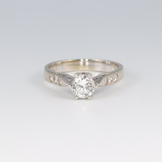 An 18ct white gold solitaire diamond engagement ring, approx. 0.75ct, set 3 diamonds to each shoulder, size O, 4.3g