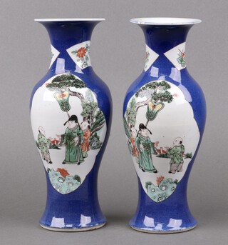 A pair of Chinese  blue ground vases with panel decoration depicting courtly figures, the base with Kangxi 4 character mark, circa 1900, 25cm 