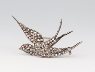 A diamond set brooch in the form of a swallow with ruby eye in a gilt metal mount 5.5cm w, 5.6g, with original box