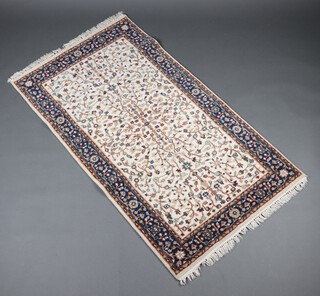 A white and blue ground Persian rug with floral medallion to the centre within a multi row border 156cm x 88cm 