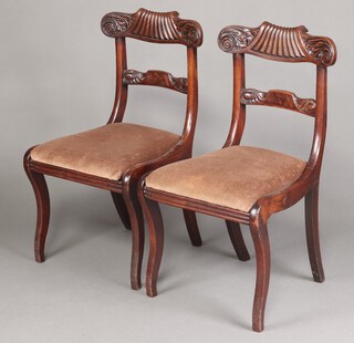 A pair of William IV carved mahogany bar bak dining chairs with shaped mid rails and drop in seats on sabre supports 