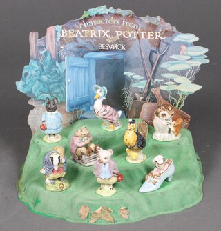 A Beswick Beatrix Potter plastic tree stump display stand and cardboard back drop, together with a collection of 8 Beswick Beatrix Potter figures -  Old Mr Brown, Piggy-Wig, Jemima Puddleduck, The Old Woman Who Lived in a Shoe, Sally Henny Penny, Tommy Brock, Pigling Bland and Mr Jackson with brown stamps 