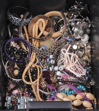 A collection of costume jewellery including necklaces, beads, bangles, etc, contained in a black plastic box 