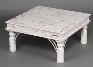 A white painted studded hardwood square coffee table, raised on turned supports 40cm h x 80cm 