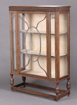 An Edwardian oak display cabinet with Grecian Key frieze to the top,  fitted shelves enclosed by an astragal glazed door 135cm h x 90cm w x 35cm d 