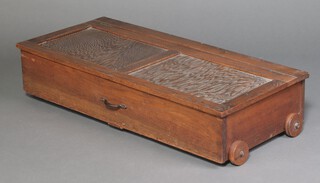 A 1930's rectangular oak underbed storage cupboard with hinged lid, on turned wooden casters 22cm h x 52cm w x 118cm l