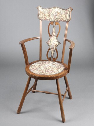 An Edwardian beech framed slat back open arm chair with upholstered seat, raised on turned supports with H framed stretcher 
