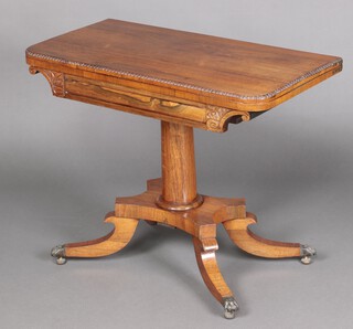 A Regency rosewood D shaped card table, raised on a turned column and triform base, with scroll feet, paw caps and casters 67cm h x 88cm w x 44cm d 