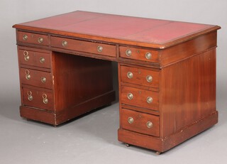 An Edwardian mahogany desk with red tooled leather writing surface, fitted 1 long and 8 short drawers with ring drop handles, raised on ceramic casters 72cm h x 136cm w x 75cm d 