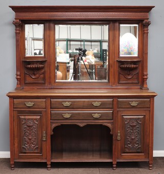 Maple & Co, an Edwardian walnut mirror backed sideboard with shaped cornice, the back fitted a triple plate mirror with brackets, raised on turned and fluted supports with Corinthian capitals, the base fitted 2 drawers above a recess flanked by 2 short drawers above cupboards enclosed by panelled doors 204cm h x 183cm w x 57cm d 