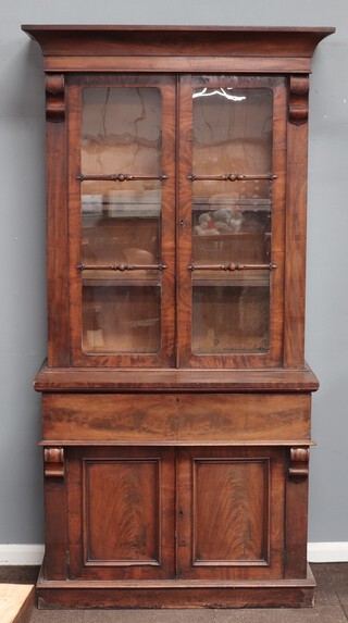 A Victorian mahogany secretaire the upper section with moulded cornice, fitted adjustable shelves enclosed by glazed panelled doors, base fitted a secretaire drawer above cupboard enclosed by panelled doors 221cm h x 107cm w x 53cm d 