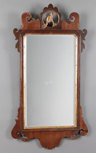 A Chippendale style rectangular plate mirror, contained in a shaped walnut frame surmounted by a figure of a bird 90cm h x 50cm w 