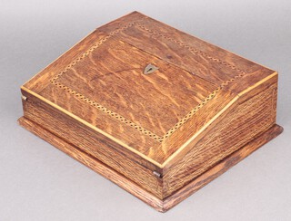 A Victorian inlaid oak writing slope, the hinged lid with brass escutcheon, the interior fitted an inkwell 11cm h x 30cm w x 26cm d 