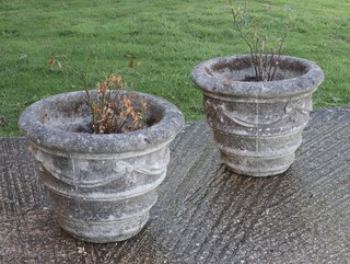 A pair of well weathered circular concrete garden urns with swag decoration 39cm h x 49cm diam. 