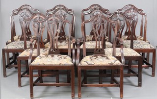 A set of 12 19th Century Hepplewhite style camel back dining chairs with pierced vase shaped slat backs and upholstered drop in seats, raised on square tapered supports with H framed stretchers - 2 carvers, 10 standard chairs 