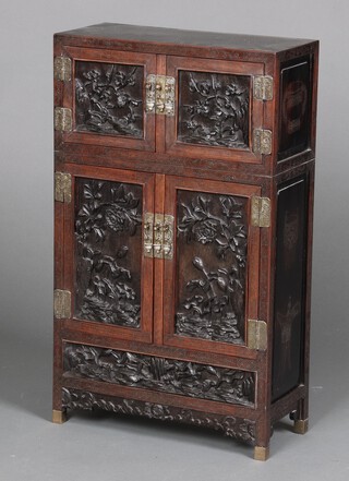 A 19th Century Chinese carved hardwood "treasure" cabinet, the upper section fitted a cupboard enclosed by panelled doors, the base fitted a cupboard with 2 shallow drawers above a twin section lidded recess enclosed by panelled doors, inlaid with silver wire throughout 68cm h x 39cm w x 17cm d 