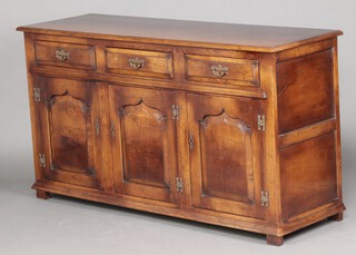 A 17th Century style oak dresser base fitted 3 long drawers above triple cupboards enclosed by panelled doors, raised on block supports 83cm h x 151cm w x 49cm d 
