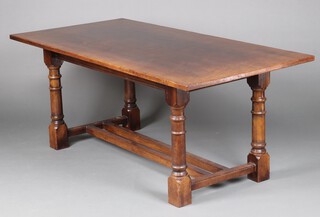 A 17th Century style elm refectory dining table with double H framed stretcher, raised on turned and block supports 74cm h x 183cm l x 95cm w 