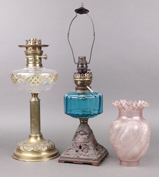 A Victorian blue glass oil lamp reservoir, raised on a waisted pierced metal base 30cm h, together with a cut glass oil lamp reservoir on a gilt metal column 43cm h, both converted to table lamps 