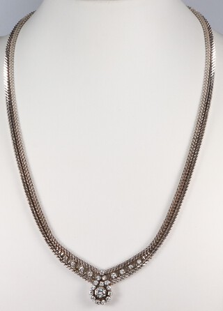 An 18ct white gold chevron link necklace with a central drop shaped diamond cluster of 15 stones with 4 further diamonds to either side, gross weight 51 grams 