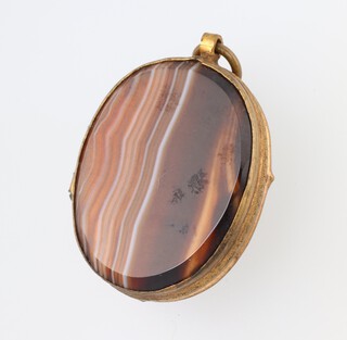 A 19th Century oval gilt and hardstone locket, the interior fitted prints of Brighton 