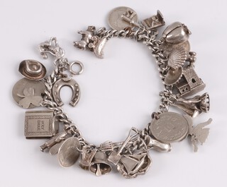 A silver curb link charm bracelet hung 28 various charms, 20cm, 71g 
