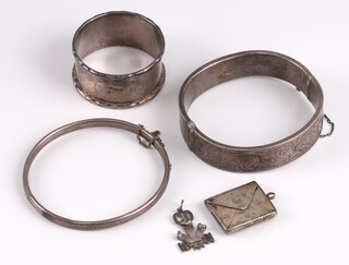 Two engraved silver bangles, a silver napkin ring, a silver stamp case and a 1981 Royal Wedding silver pendant 48g 