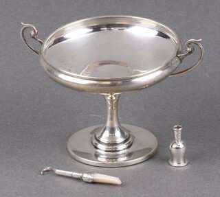 A silver twin handled comport 8cm Birmingham 1914, marks rubbed (base misshapen and charged) together with a small model of a bottle 2.5cm and a silver button hook (f) 