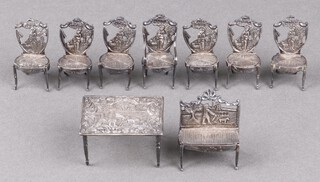 A Dutch miniature silver model of a table decorated a figure with dog and windmill, import mark Birmingham 1907 together with a miniature Continental silver 8 piece drawing room suite comprising sofa, 6 standard chairs (1 a/f) and a carver chair, all with London import silver mark 1907,  136g 