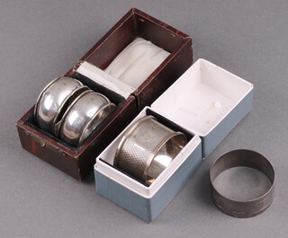 A silver napkin ring with engine turned decoration London 1960 and 3 other napkin rings (some with dents) 41g 