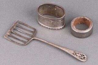 An Edwardian pierced silver sardine lifter Sheffield 1904 by James Dixon & Sons, an oval engraved silver napkin ring (marks rubbed) 58g together with a wine bottle collar  